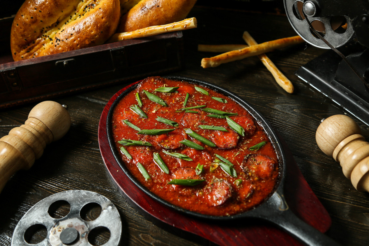 saucisse tranchee dans des pates aux tomates garnies de poivron